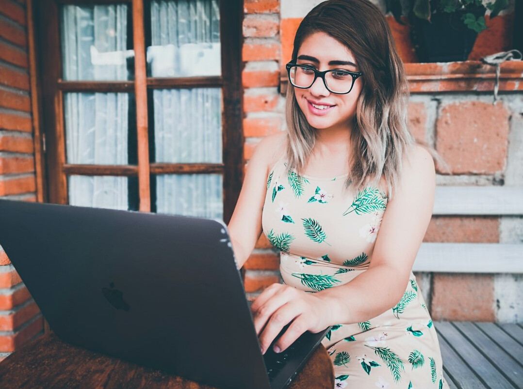 woman programmer smiling at laptop